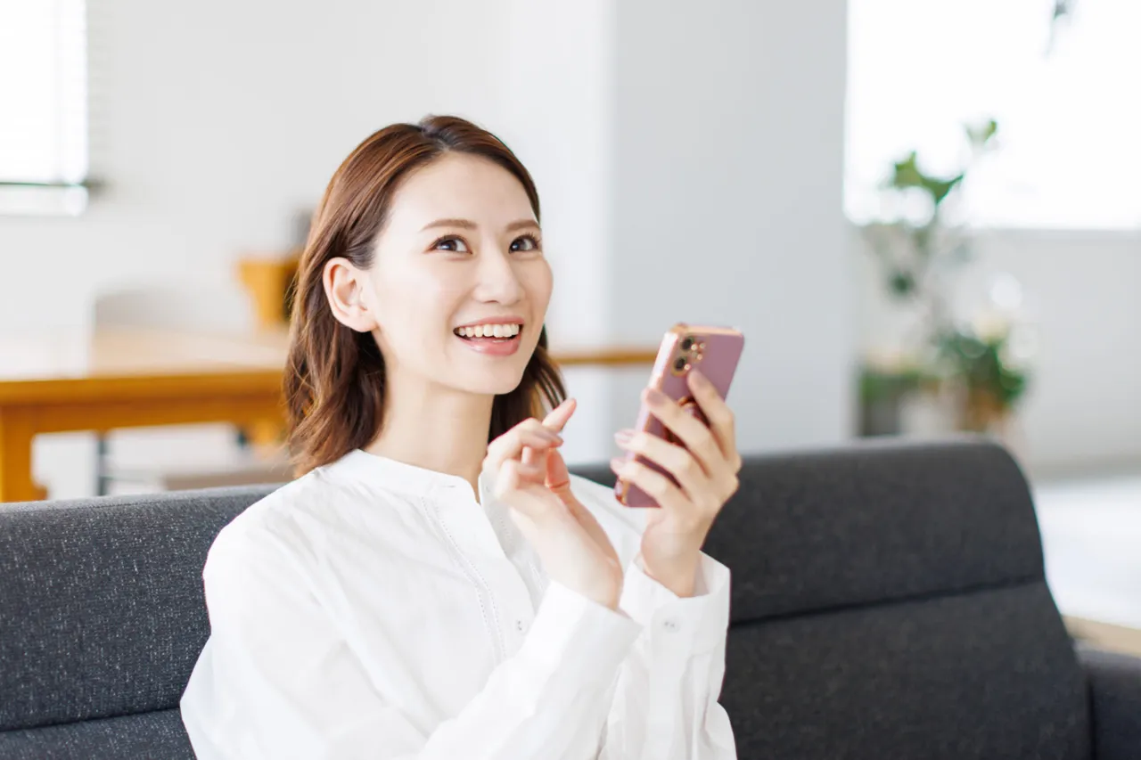 スマホで仮交際中の男性とのLINEを楽しむ30代の女性